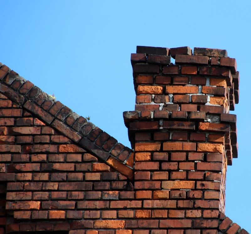 Damaged chimney on an Bedford home showing cracks and missing mortar
